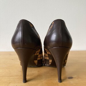 Puede incluir: Un par de tacones altos de cuero marr&oacute;n. Los tacones tienen un patr&oacute;n tejido en los laterales y una punta afilada. Los tacones miden aproximadamente 10 cm de alto.