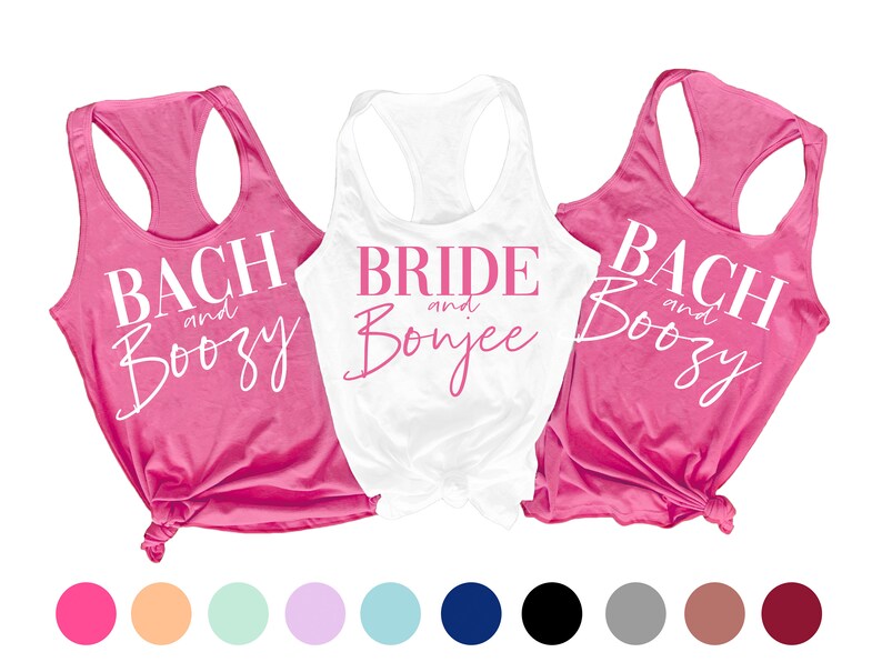 May include: Three tank tops with different text printed on them. The tank tops are pink, white, and pink. The text on the pink tank tops says "Bach and Boozy" and the text on the white tank top says "Bride and Bonjee".