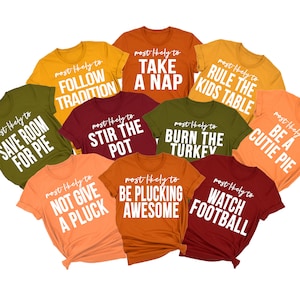 May include: Ten different coloured t-shirts with white text that says 'most likely to' followed by a Thanksgiving-themed phrase. The phrases are: 'follow tradition', 'take a nap', 'rule the kids table', 'save room for pie', 'stir the pot', 'burn the turkey', 'be a cutie pie', 'not give a pluck', 'be plucking awesome', and 'watch football'.