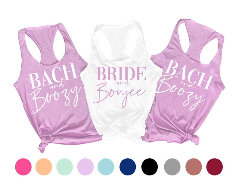 May include: Three tank tops with the text "Bach and Boozy", "Bride and Bonjee", and "Bach and Boozy" in white and pink lettering on a lavender and white background. The tank tops are displayed on a white background with a row of colored circles below.