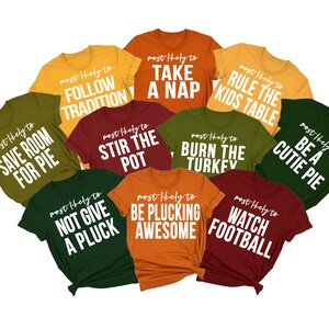 May include: Ten different t-shirts with humorous Thanksgiving-themed sayings printed in white on various coloured shirts. The sayings include "Save Room for Pie", "Follow Tradition", "Take a Nap", "Rule the Kids Table", "Stir the Pot", "Burn the Turkey", "Be a Cutie Pie", "Not Give a Pluck", "Be Plucking Awesome", and "Watch Football".