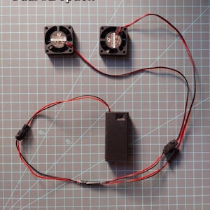 May include: Dual #2 option for a project with two small black fans, a battery pack, and red and black wires.
