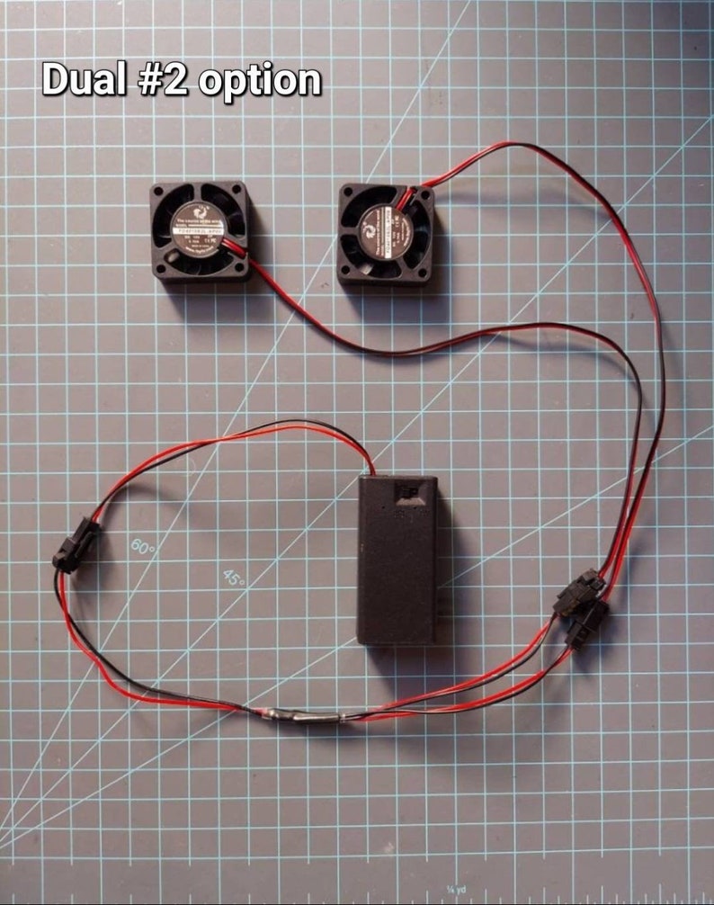 May include: Dual #2 option for a project with two small black fans, a battery pack, and red and black wires.