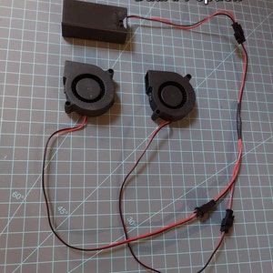 May include: Dual #1 option for a DIY project with two black fans, a black battery pack, and red and black wires.