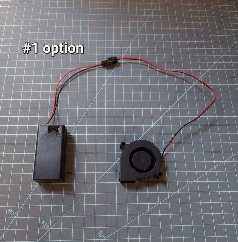 May include: A black battery pack with red and black wires connected to a black fan with a black connector. The text '#1 option' is visible in the top left corner of the image.