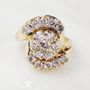 May include: A gold ring with a large cluster of diamonds set in a swirling design.