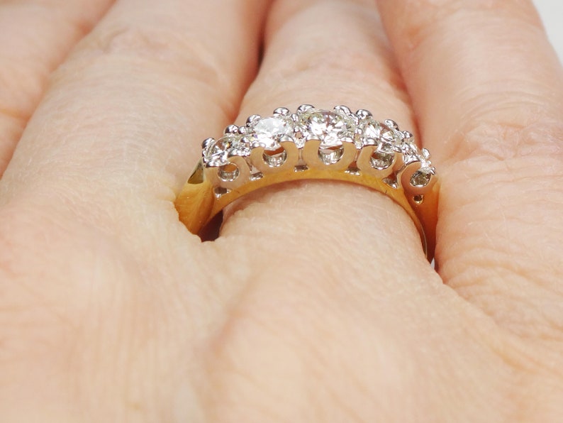 May include: A gold band ring with a row of sparkling diamonds set in a prong setting.