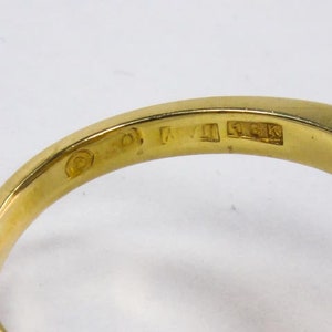 Op de afbeelding: Close-up van de binnenkant van een gouden ring met de markeringen "14K" en "KVI" op de band.