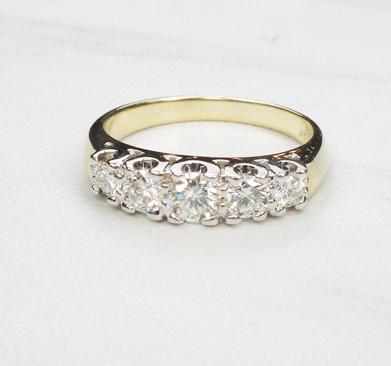 May include: A gold band ring with a row of six round diamonds set in white metal.