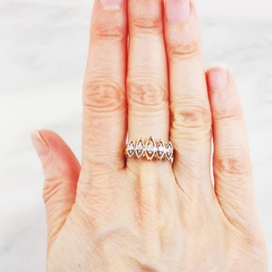 K&ouml;nnte beinhalten: Ein Goldring mit einer Reihe von sechs Marquise-Diamanten, die in die Band gefasst sind.