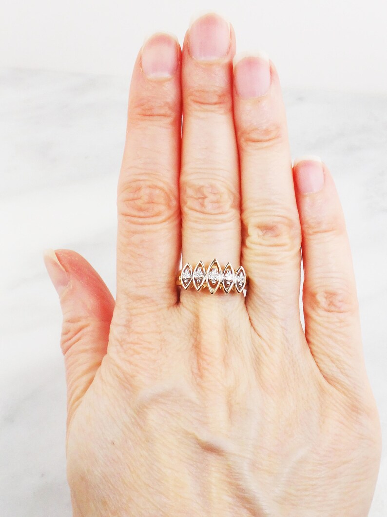 K&ouml;nnte beinhalten: Ein Goldring mit einer Reihe von sechs Marquise-Diamanten, die in die Band gefasst sind.