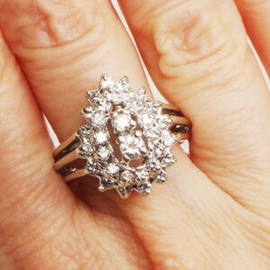 Op de afbeelding: Een zilveren ring met een traanvormig ontwerp bezet met meerdere kleine diamanten.