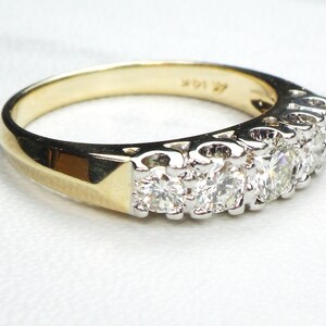 May include: A gold band ring with a row of small, round diamonds set in white metal.