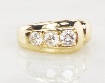 May include: A gold band ring with three round diamonds set in a row. The ring has a curved design.