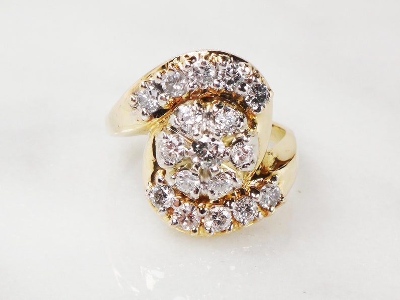 May include: A gold ring with a large cluster of diamonds set in a swirling design.