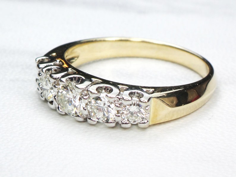 May include: A gold and silver band ring with a row of round, clear diamonds.