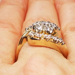 May include: A gold ring with a cluster of small diamonds set in a floral design.