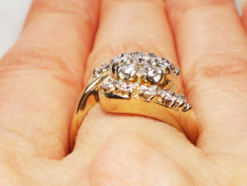 May include: A gold ring with a cluster of small diamonds set in a floral design.