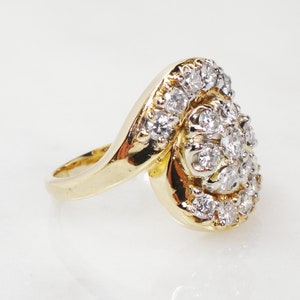 May include: A gold ring with a swirl design set with a cluster of diamonds.
