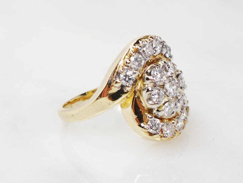 May include: A gold ring with a swirl design set with a cluster of diamonds.