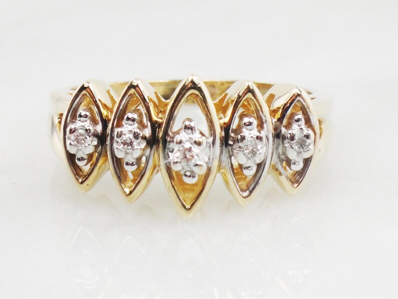 K&ouml;nnte beinhalten: Ein Goldring mit f&uuml;nf marquisef&ouml;rmigen Fassungen, jede mit einem Cluster aus kleinen Diamanten.
