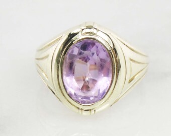 May include: A gold ring with a large oval amethyst gemstone. The ring has a simple design with a smooth band and a raised setting for the stone.