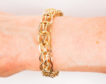 May include: A gold chain bracelet with a unique interlocking design.