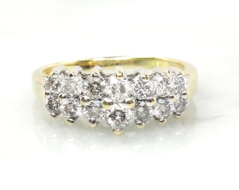 May include: A gold ring featuring a cluster of round-cut diamonds. The diamonds are set closely together, creating a sparkling effect. The ring has a classic design, suitable for various occasions.