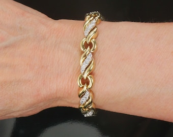 May include: A gold bracelet with a chain link design, accented with small diamonds.
