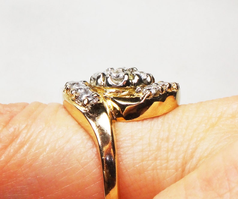 May include: A gold ring with a cluster of clear diamonds set in a twisted band.