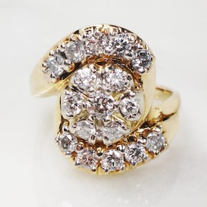 May include: A gold ring with a large cluster of diamonds set in a swirl design.