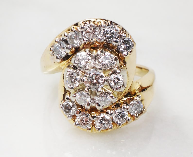May include: A gold ring with a large cluster of diamonds set in a swirl design.