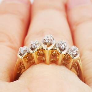 K&ouml;nnte beinhalten: Ein goldener Ring mit f&uuml;nf kleinen Diamanten, die in einem Herzform-Design gefasst sind.