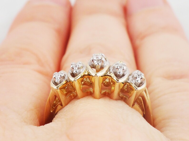 K&ouml;nnte beinhalten: Ein goldener Ring mit f&uuml;nf kleinen Diamanten, die in einem Herzform-Design gefasst sind.