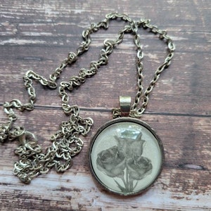 Roses pendant necklace made with King of Battle and Blood book pages