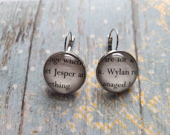 Pendientes colgantes de Jesper y Wylan hechos con páginas del libro Seis de Cuervos