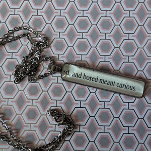 May include: A white ceramic mug with a black handle and the text "But First, Coffee" in a bold, black font. The mug is set against a neutral background, highlighting its simple design.