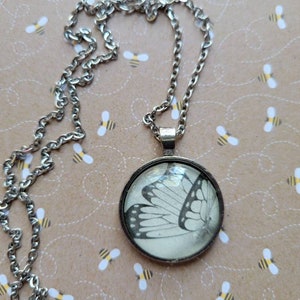 Butterfly pendant necklace made with Queen of Myths and Monsters book pages
