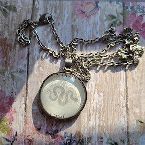 Serpent pendant necklace made with Kingdom of the Cursed book pages