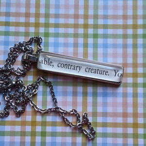 Contrary Creature pendant necklace made with Sorcery of Thorns book pages