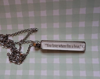 Collar colgante "Te encanta cuando soy una mocosa" hecho con páginas del libro Enchantra