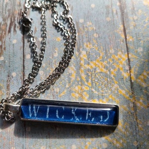 Blue Wicked pendant necklace made with Kingdom of the Cursed book pages