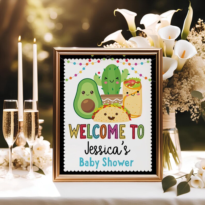 May include: A welcome sign for a baby shower with a colorful border and a white background. The sign features a cartoon avocado, cactus, and burrito with smiling faces. The text reads "Welcome to Jessica's Baby Shower".
