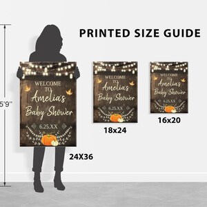 May include: A printed size guide for a baby shower sign. The sign features a rustic wood background with a fall theme, including pumpkins, leaves, and string lights. The text on the sign reads "Welcome to Amelia's Baby Shower". The guide shows the sign in three different sizes: 18x24 inches, 16x20 inches, and 24x36 inches.