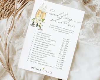 May include: A white wedding game card with the text "The Wedding Shoe Game." The card features illustrations of champagne glasses and flowers. The game includes questions for the couple to answer. The names "Dannica" and "Billy" are printed at the bottom.