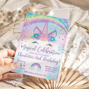 May include: A rainbow-themed invitation for a child's 2nd birthday party. The invitation features a unicorn with a flower crown and the text "Over the Rainbow for a Magical Celebration. Please join us to celebrate Charlotte's 2nd Birthday!"