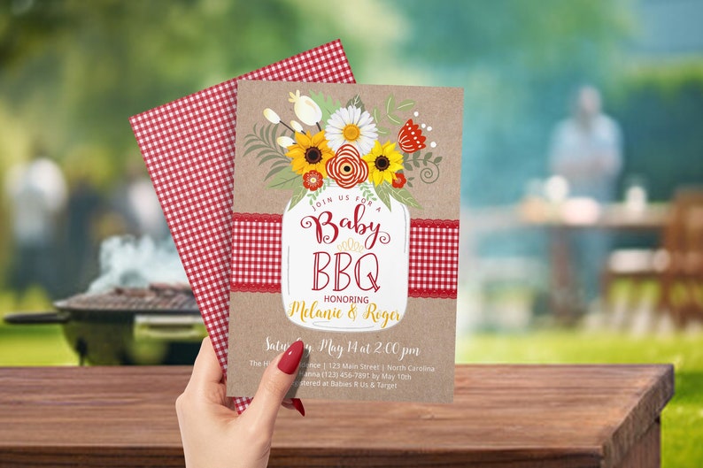 May include: A rustic brown invitation with a red and white gingham ribbon. The invitation features a mason jar filled with sunflowers, daisies, and red flowers. The text on the invitation reads "Join us for a Baby BBQ Honoring Melanie & Roger Saturday, May 14 at 2:00pm The Home 123 Main Street, North Carolina Hanna (123) 456-7891 by May 10th Registered at Babies R Us & Target"