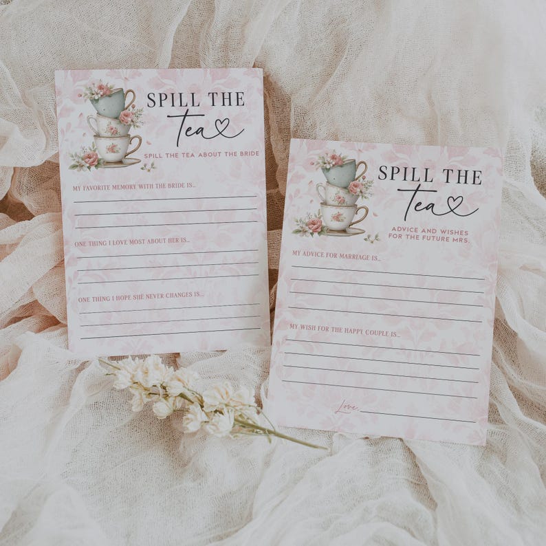 Op de afbeelding: Twee roze en witte "Spill the Tea" bruidsdouche spelkaarten. De kaarten bevatten bloemen theekopjes illustraties en vragen als "Mijn favoriete herinnering met de bruid is..." en "Mijn advies voor het huwelijk is..."