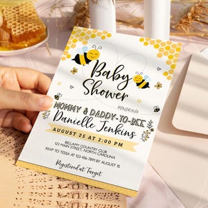 Może przedstawiać: Białe zaproszenie na baby shower z ż&oacute;łto-czarnym wzorem plastra miodu. Zaproszenie zawiera napis "Baby Shower" i "Mommy & Daddy-to-Bee Danielle Jenkins". Data i godzina imprezy to 25 sierpnia o 14:00. Miejscem imprezy jest Bellamy Country Club, 123 Main Street, Karolina P&oacute;łnocna. Informacje RSVP należy przekazać Tessie pod numer 123-456-7891 do 15 sierpnia. Zaproszenie zawiera r&oacute;wnież napis "Registered at Target".