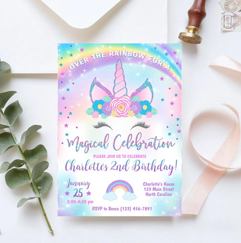 May include: A rainbow-themed invitation for a child's 2nd birthday party. The invitation features a unicorn with a sparkly horn and a flower crown. The text reads "Over the Rainbow for a Magical Celebration Charlotte's 2nd Birthday!" with the date, time, and RSVP information.